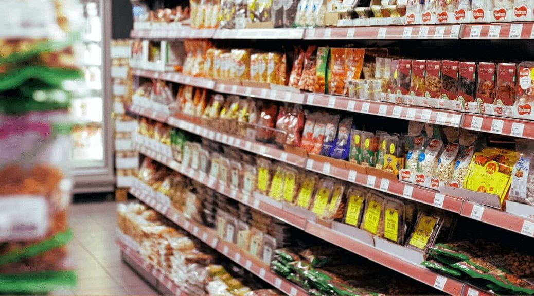 Grocery store shelves showcasing visual merchandising techniques with various snacks and nuts.