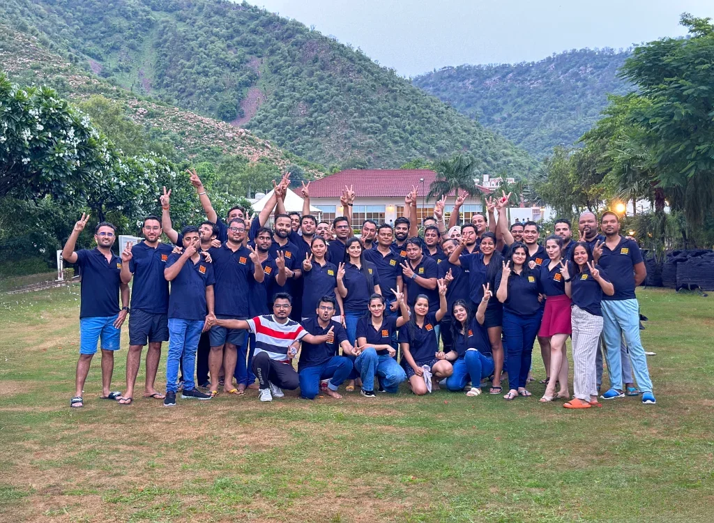 Large group of people connecting outdoors, making peace signs.