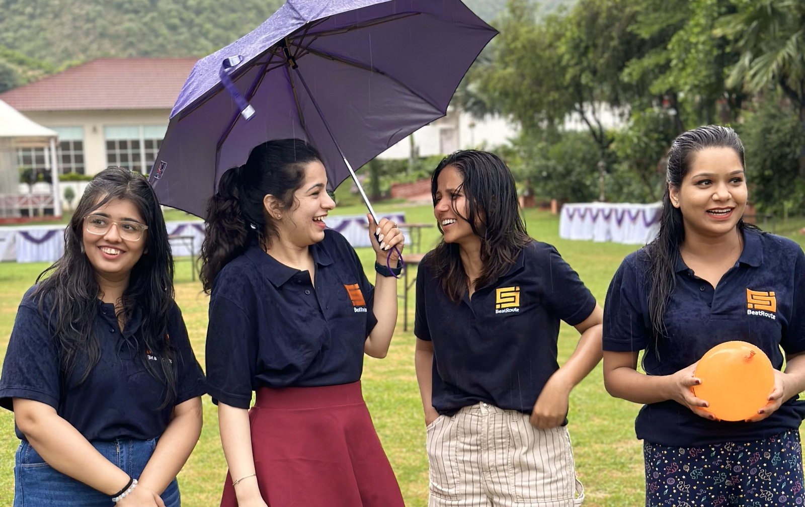 Happy BeatRoute team building in the rain; strong company culture.