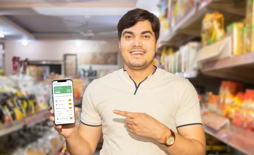 Man in store showing retailer app on phone.