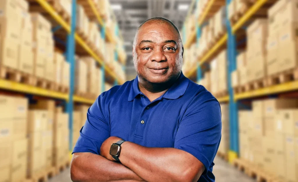 BeatRoute: Man in blue polo shirt, arms crossed, warehouse background.