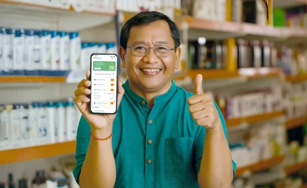 Smiling man shows BeatRoute app on phone, giving thumbs up in retail store.