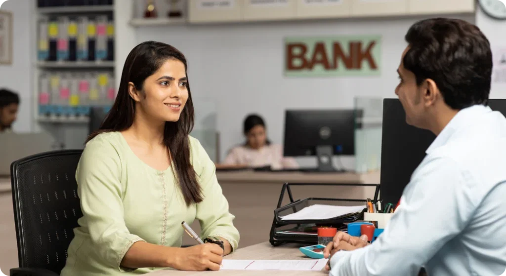 SFA for BFSI Industry: Woman signing documents with a bank representative.
