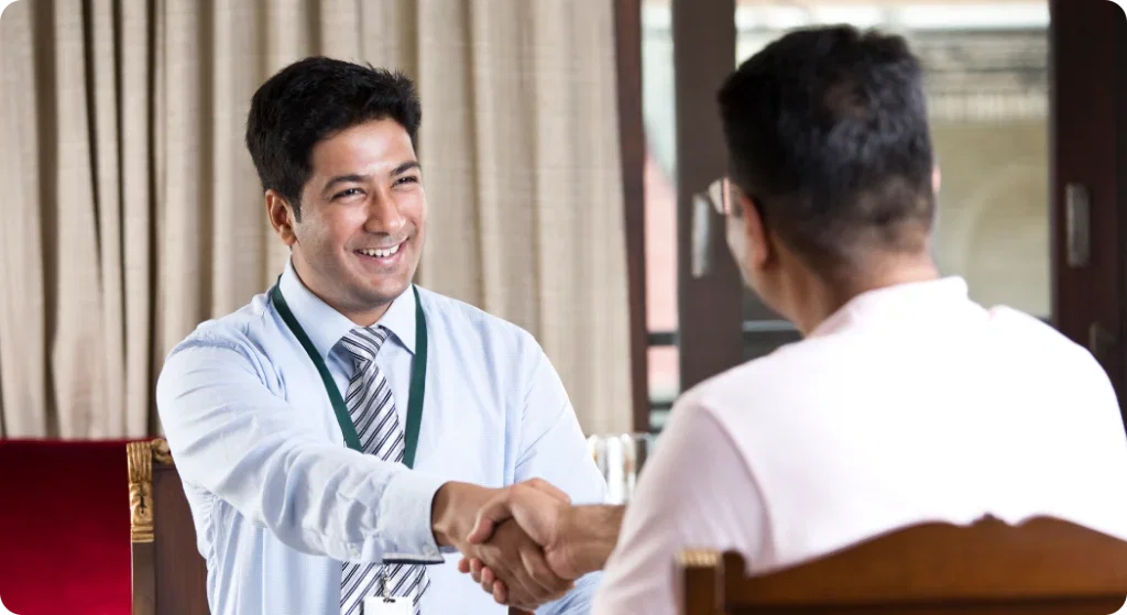 Smiling businessman shaking hands, SFA for BFSI industry.